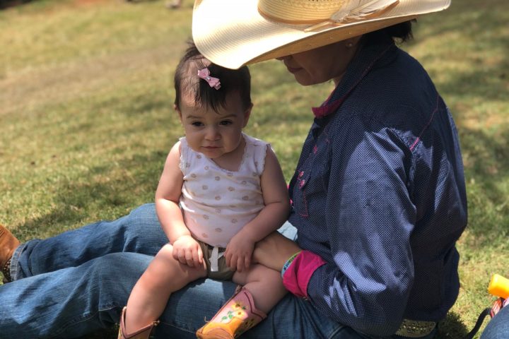 a little boy that is sitting in the grass